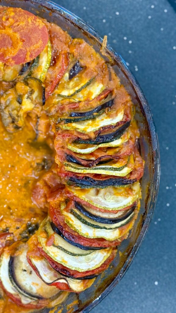 Warzywne ratatouille ułożone warstwowo w naczyniu żaroodpornym, przedstawiające niskoglikemiczny posiłek, który może zalecić dietetyk online w cukrzycy.