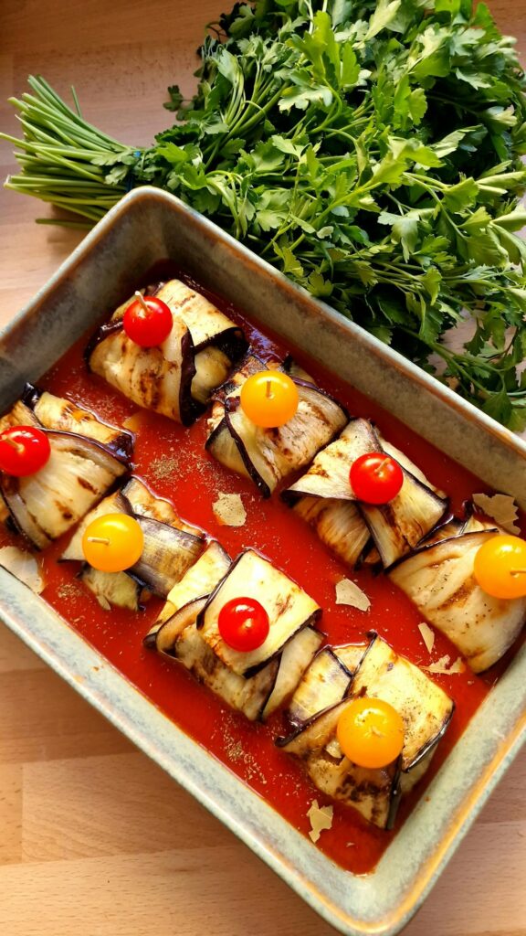 Faszerowane roladki z bakłażana z pomidorkami koktajlowymi w czerwonym sosie, przygotowane jako zbilansowane danie obiadowe przez dietetyka online w cukrzycy.